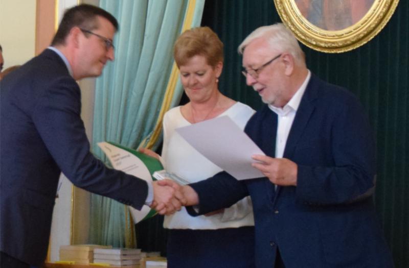 Na zdjęciu burmistrz Tomasz Chudy odbiera nagrodę z rąk profesora Jerzego Stępnia. W środku prezes stowarzyszenia Razem dla Konarzewa Barbara Łasińska