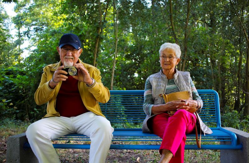 na zdjęcia para emerytów siedząca na ławce w parku