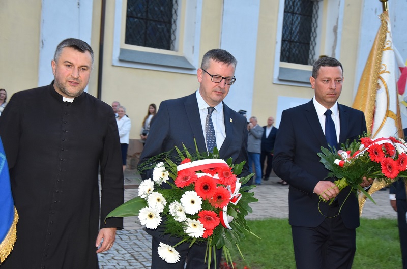 Na zdjęciu Członek Zarządu Powiatu Krotoszyńskiego, Burmistrz Zdun oraz ks. Krzysztof Śliczny w trakcie składania wiązanek kwiatów